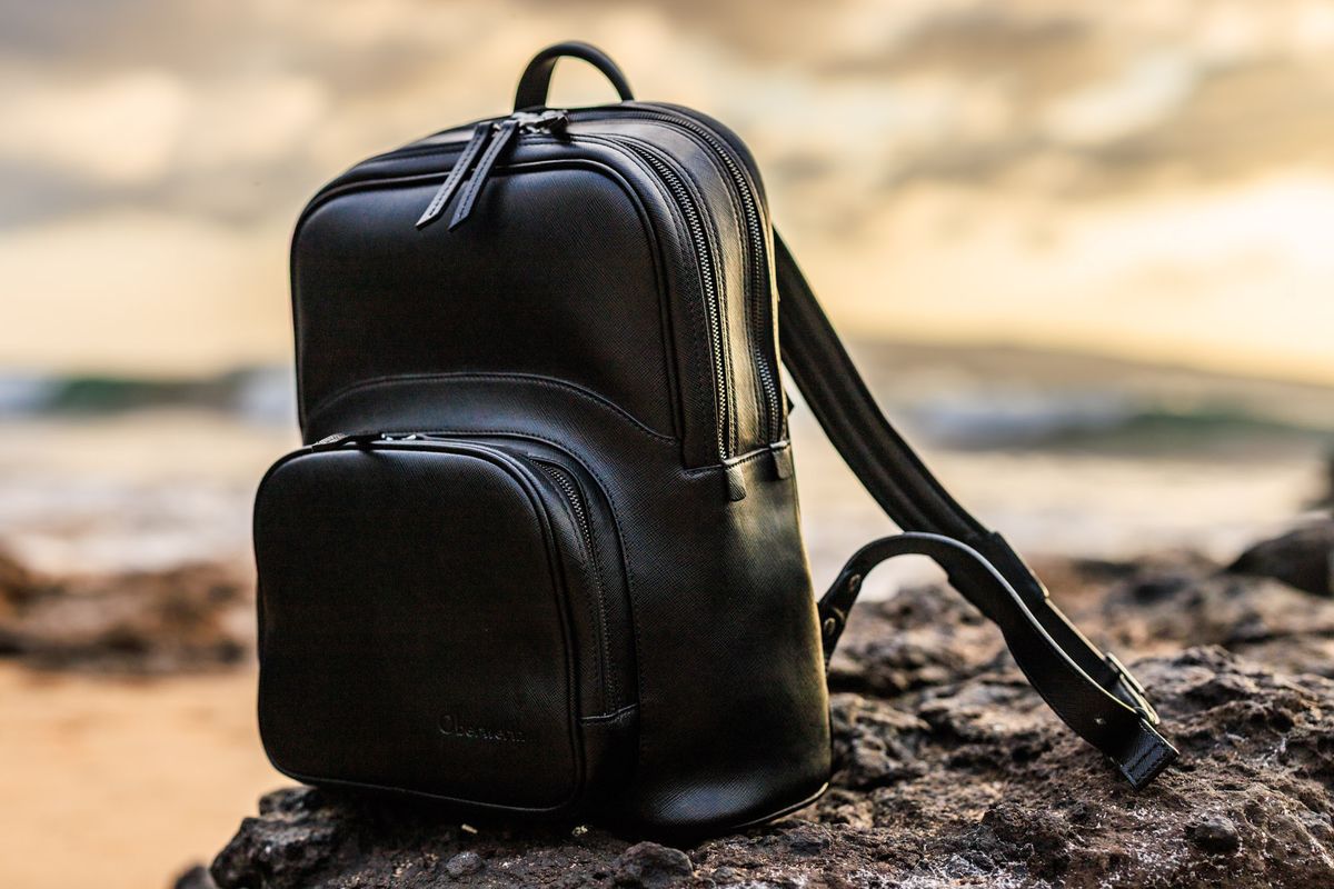 The Oberwerth Q Backpack in black leather, on lava rock at sunset in Maui