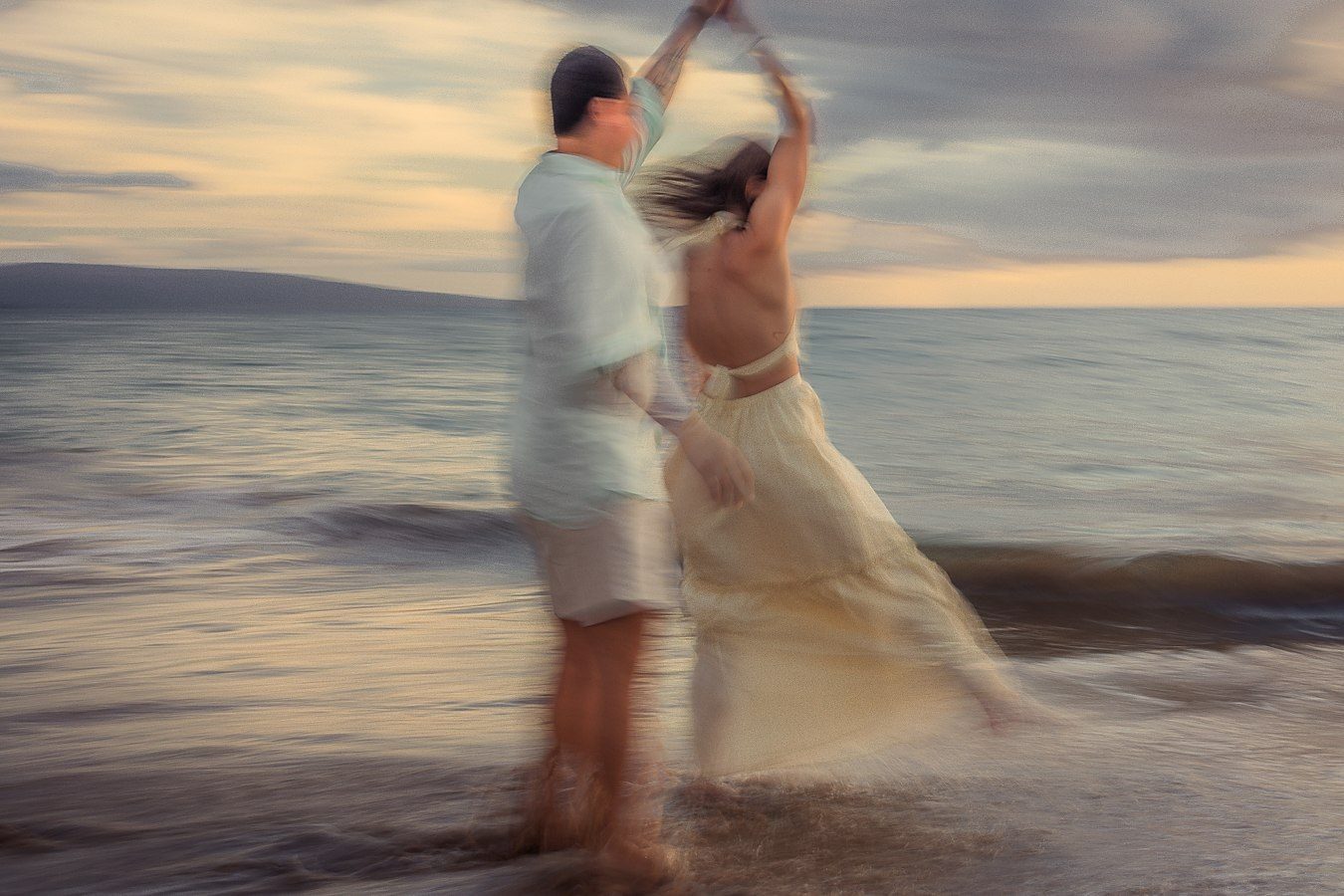 Color long exposure of a couple dancing on the shore at dusk